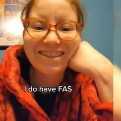 Uśmiechnięta kobieta w okularach mówi: "I do have FAS". Opowiada o FAS u dorosłych.