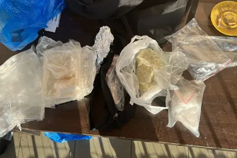 Różne substancje w foliowych i plastikowych opakowaniach na drewnianym stole.