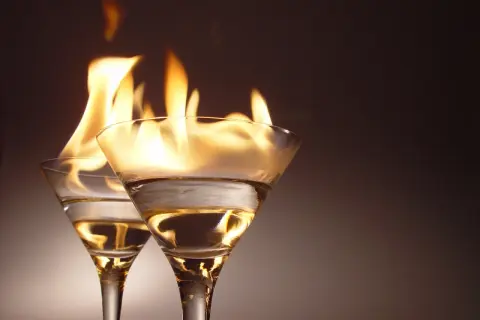 Dwa kieliszki z płonącym alkoholem, jakby Molly przygotowywała ognisty drink.