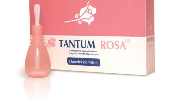Tantum Rosa, lek dopochwowy w płynie, w różowej buteleczce z aplikatorem, obok pudełka z różą.