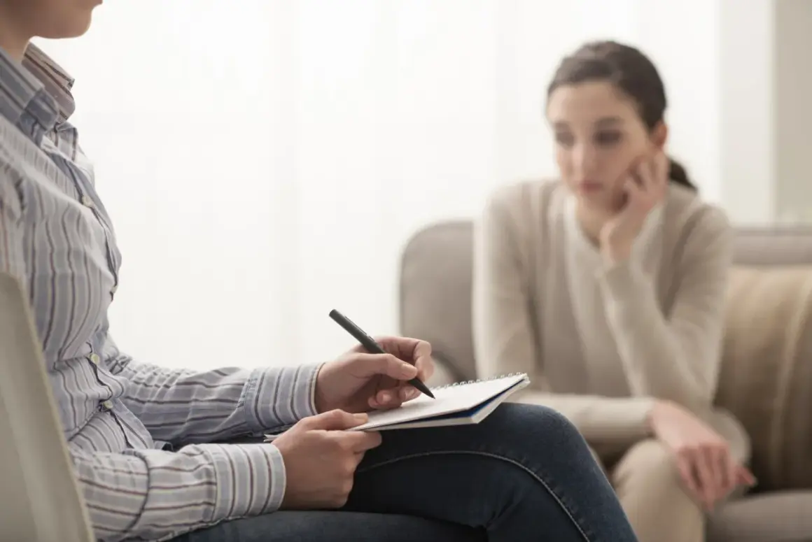 Terapia uzależnień: terapeuta notuje, pacjentka słucha. Zastanawiasz się, ile zarabia terapeuta uzależnień?