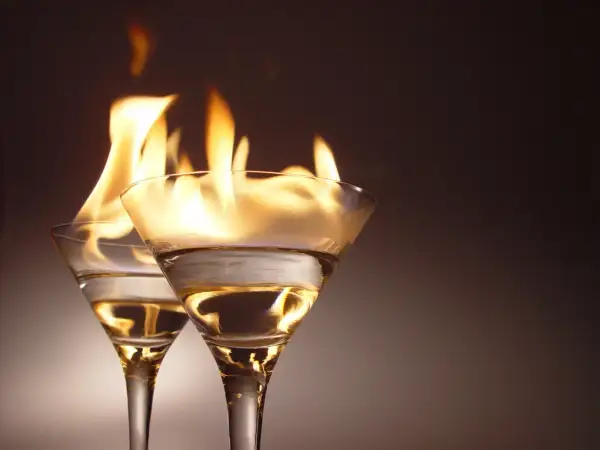 Dwa kieliszki z płonącym alkoholem, jakby Molly przygotowywała ognisty drink.
