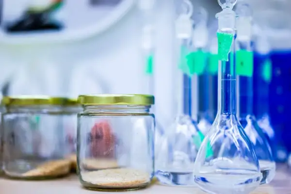 Laboratorium przygotowuje się do analizy. Widać słoiki z próbkami i kolby z płynami, gotowe do wykonania testu na narkotyki z krwi.